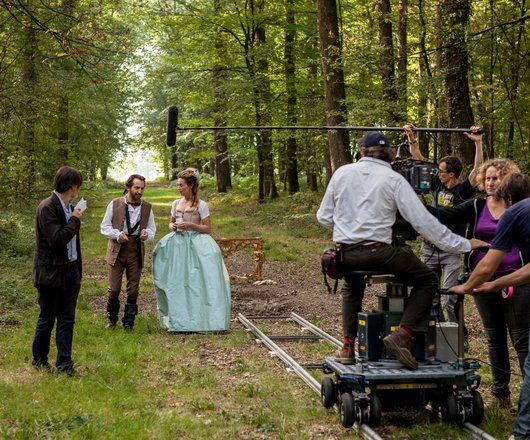 Tournage d'une scène de cinéma  avec deux acteurs se promenant en foret